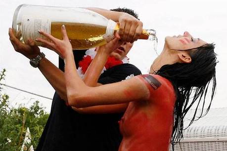 De champagne vloeit rijkelijk over de beschilderde vrouwen lichamen De champagne vloeit rijkelijk over de beschilderde vrouwen lichamen