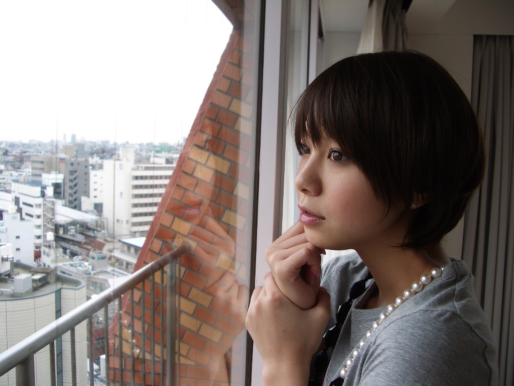 丸いフォルムのショートヘアで窓の外を眺める田中美保