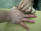 手に釘を打つ男